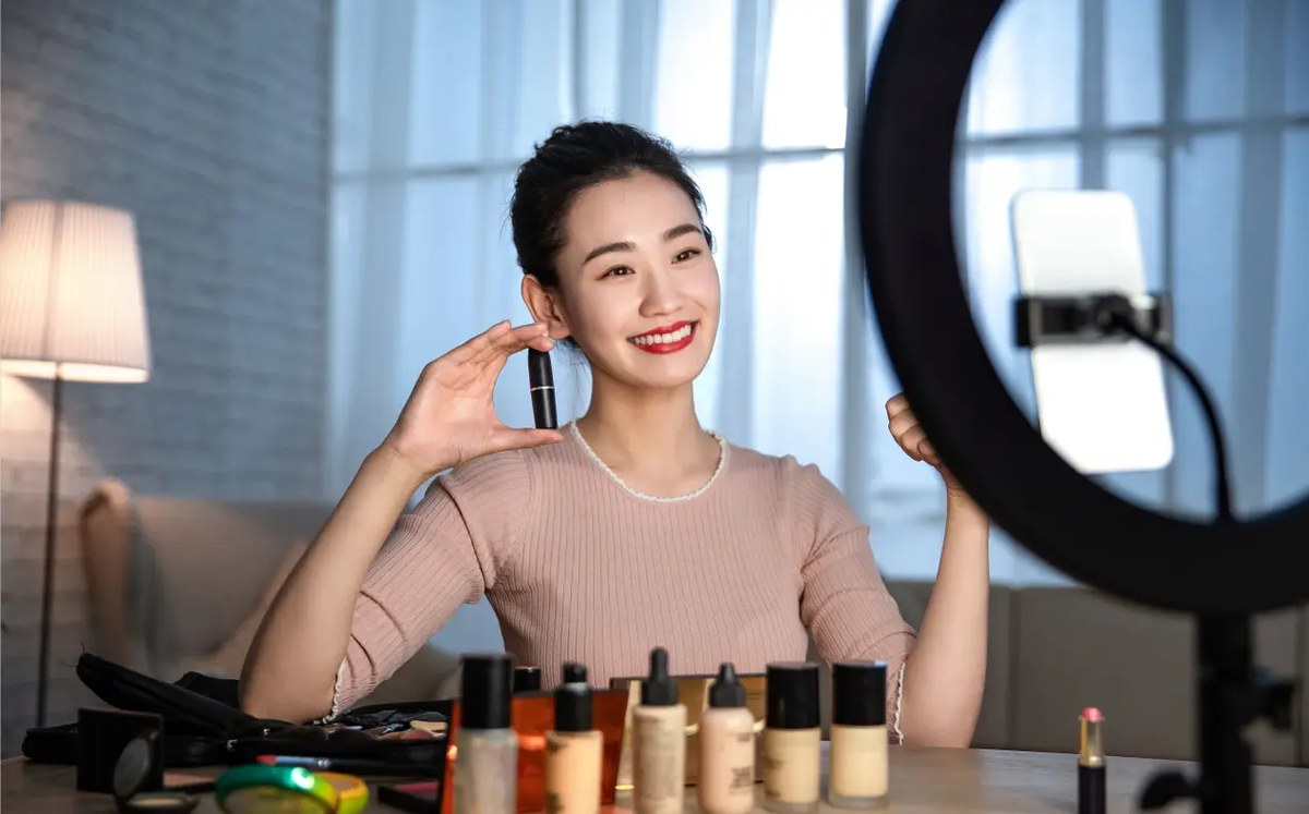 A beauty creator filming in front of a ring light
