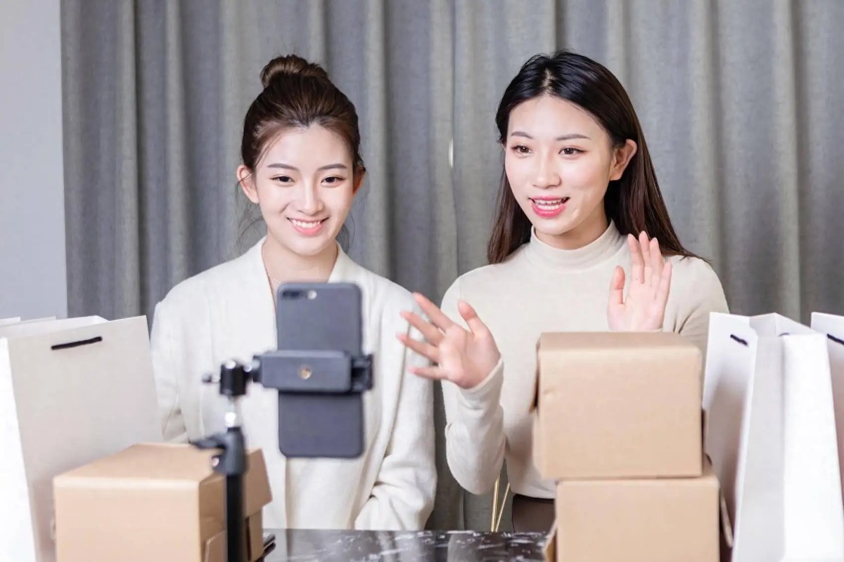 两位主播在纸箱旁介绍产品