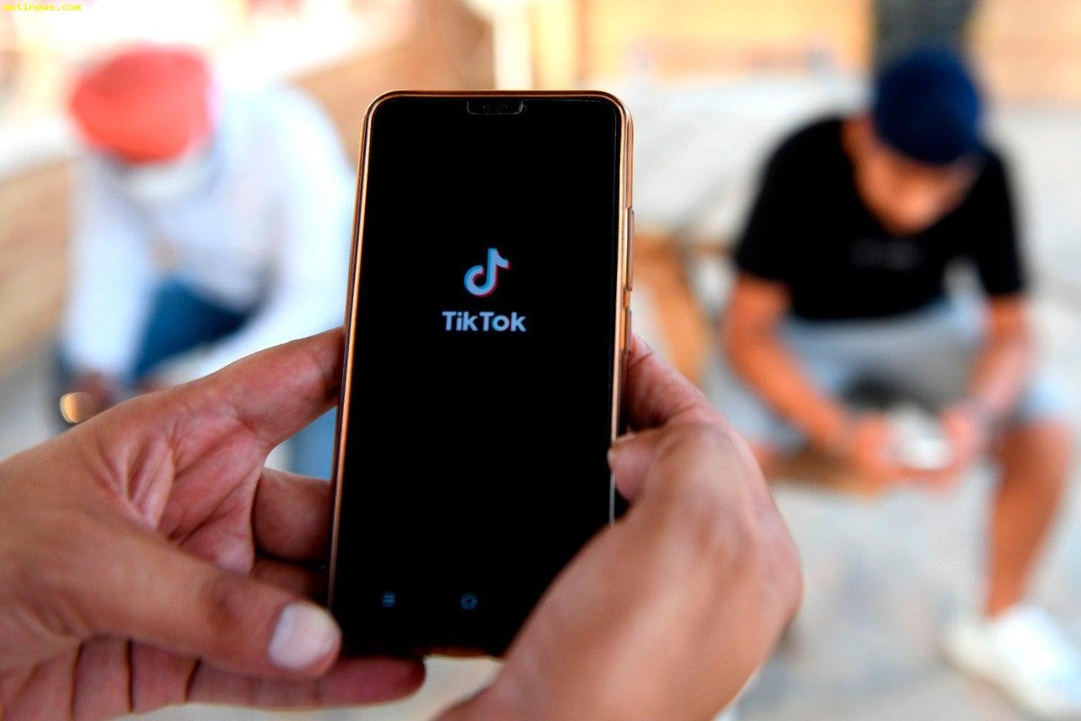 A phone held up showing a creator account status