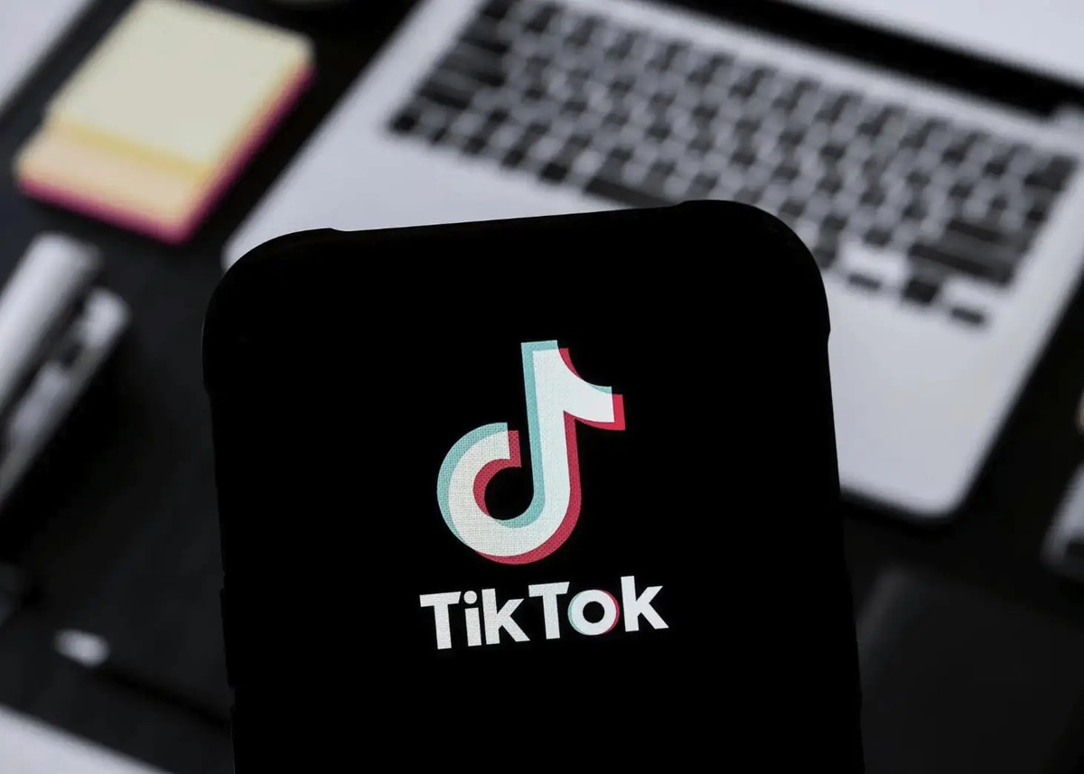 Ponsel menampilkan TikTok di atas keyboard laptop