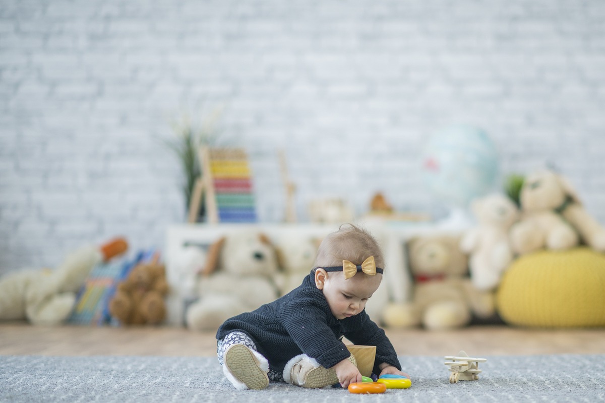A toddler playing on a mat in a compact living room
