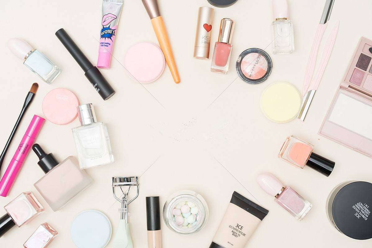 Flat-lay kosmetik, kuas, dan skincare di permukaan terang